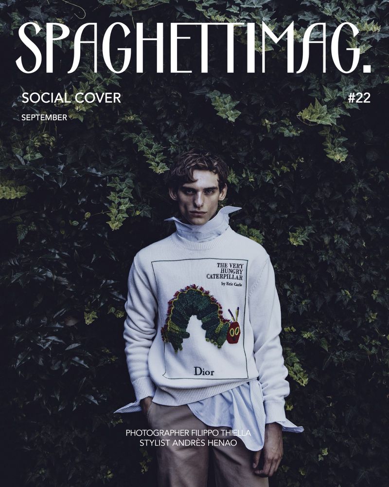 Digital magazine cover featuring a male model wearing a white graphic sweater and shirt against lush green ivy foliage.