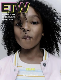 Young child with curly dark hair wearing a pink jacket and striped top against a plain white background