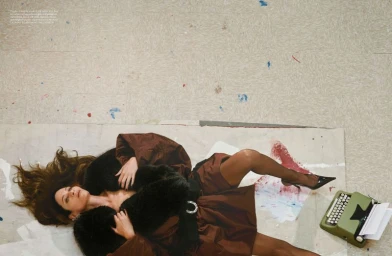 Model Frankie Rayder lying on a painted studio floor with a green typewriter for AnOther Magazine.