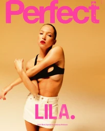 Model Lila Moss wearing a black top and white miniskirt against warm backdrop with bold pink magazine text overlay
