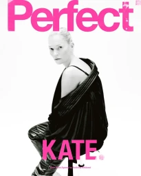 Kate Moss seated wearing a black top and dark trousers against a bright white background with bold pink text overlay