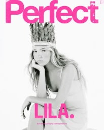 Model Lila Moss wearing a feathered headdress and light dress against a white background for The Perfect Magazine