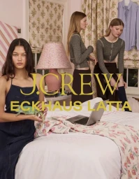 Three models in a bedroom setting with a pink lamp and patterned floral curtains, one holding a small green lizard.