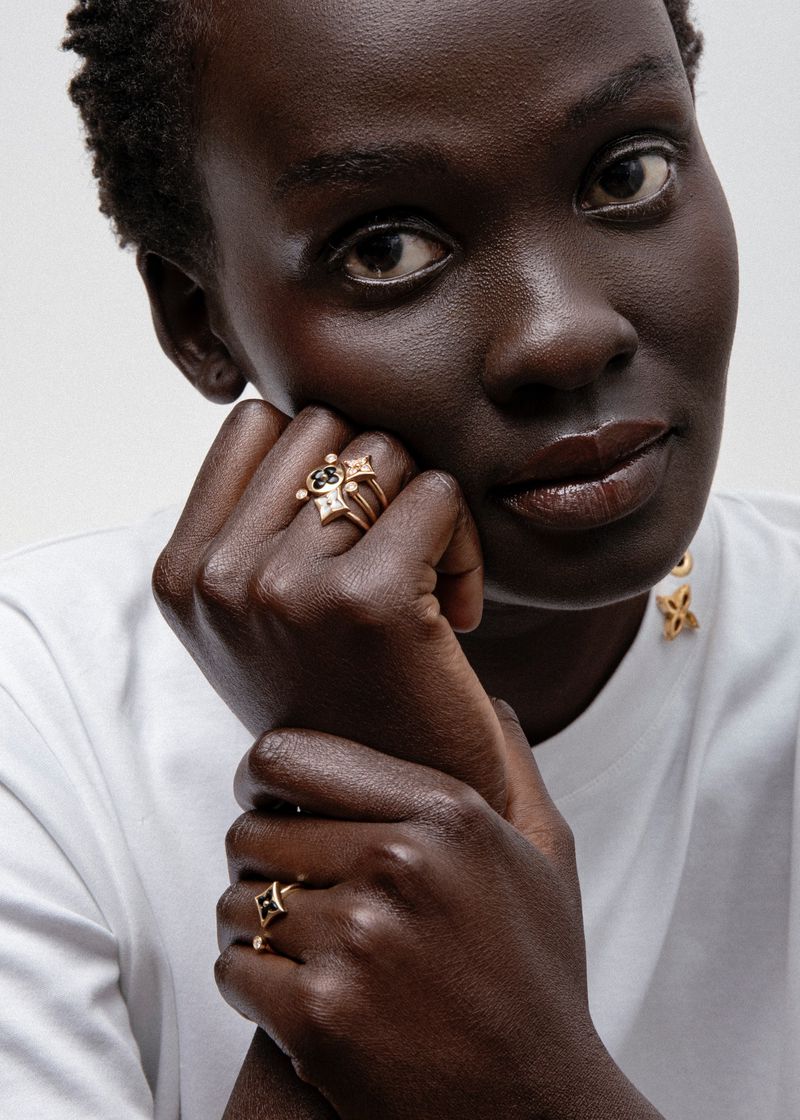 Close portrait of a model wearing gold rings and earrings against a white background for 5ELEVEN Magazine