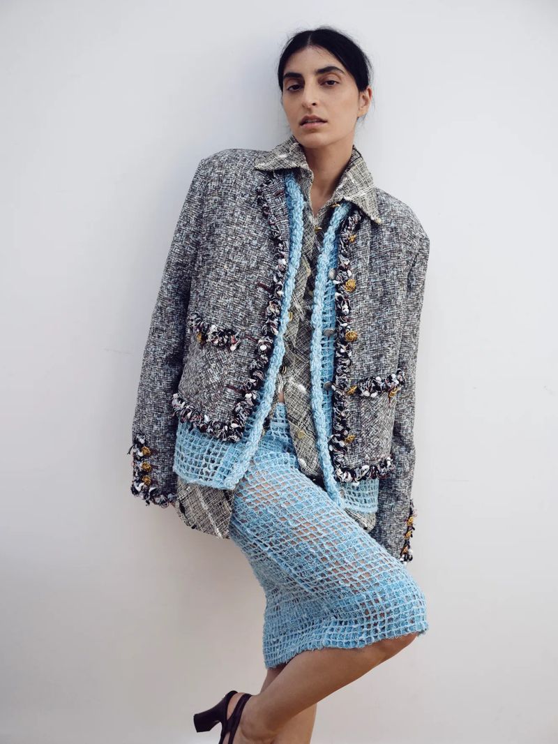 Model wearing a grey tweed jacket and blue mesh skirt against a plain white background for The Sunday Times Style Magazine