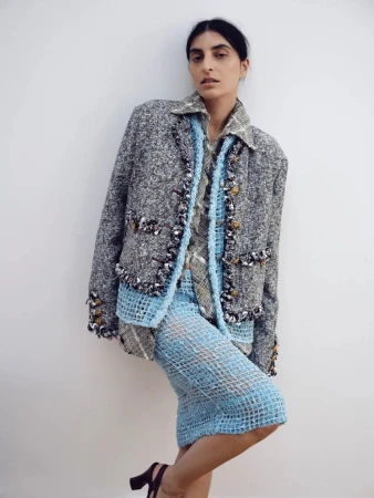 Model wearing a grey tweed jacket and blue mesh skirt against a plain white background for The Sunday Times Style Magazine