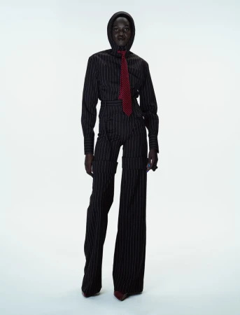 Model Caren Jepkemei wearing a pinstripe suit and matching hood with red tie for 10 Magazine editorial photographed by Ferry van der Nat.