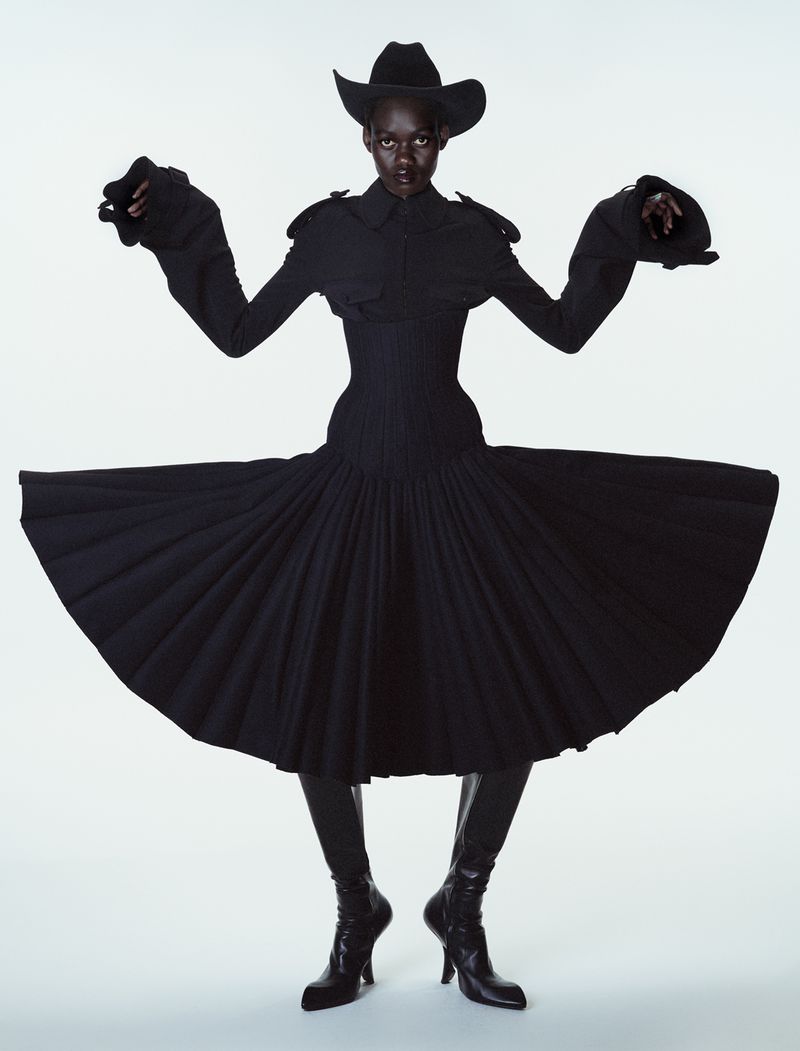 Model Caren Jepkemei wearing a black structured dress and cowboy hat in 10 Magazine editorial by Ferry van der Nat.