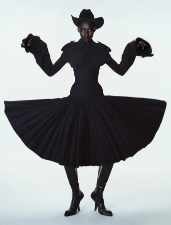 Model Caren Jepkemei wearing a black structured dress and cowboy hat in 10 Magazine editorial by Ferry van der Nat.