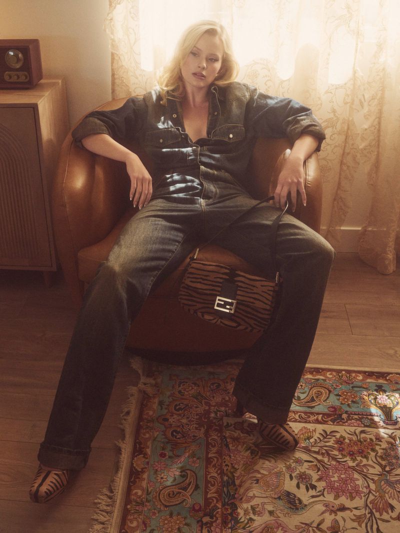 Ava Phillippe seated in a leather armchair wearing denim attire with an animal print handbag for Flaunt