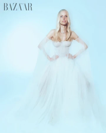 Leonie Hanne in an off-shoulder white tulle gown against a pale blue background for Harper's Bazaar Vietnam, photographed by Giuseppe Vitariello.