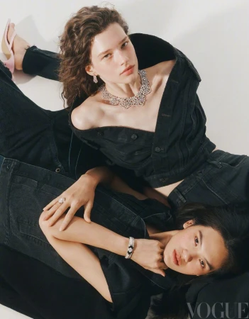 Two female models wearing black denim and fine diamond jewelry posing on a white studio background for Vogue China.
