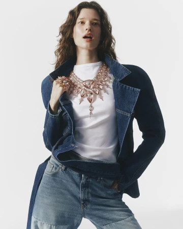 Model wearing a denim jacket and statement crystal necklace against a plain white background for Vogue China.
