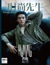 Portrait of Gong Jun lounging on a dark leather sofa wearing a grey jacket over a white top for Esquire China magazine.