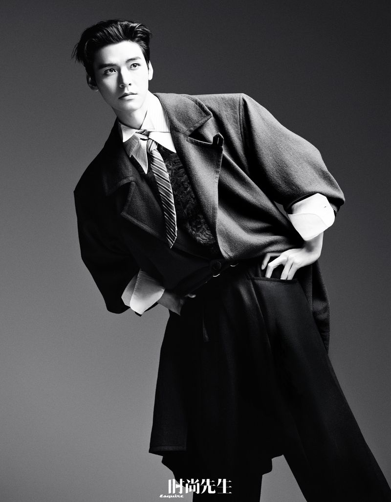 Gong Jun wearing a tailored jacket and striped tie against a grey gradient background in an editorial for Esquire China