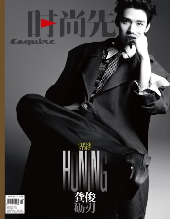 Monochrome fashion editorial portrait of Gong Jun wearing a dark suit jacket and tie against a grey seamless background for Esquire China.