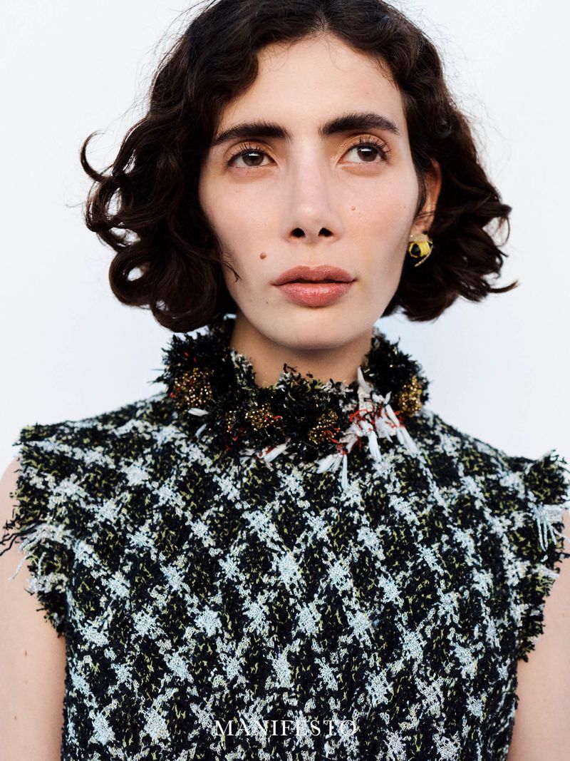 Close-up portrait of model Trinidad Castaño in a textured tweed top against a white background for Manifesto Magazine.