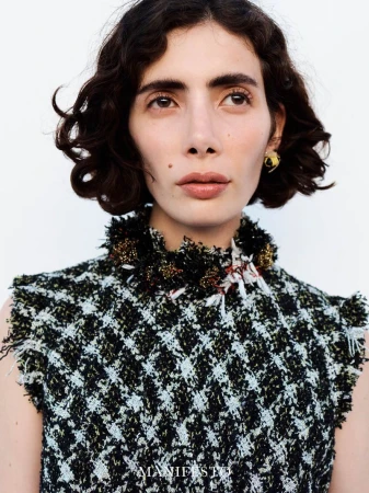 Close-up portrait of model Trinidad Castaño in a textured tweed top against a white background for Manifesto Magazine.