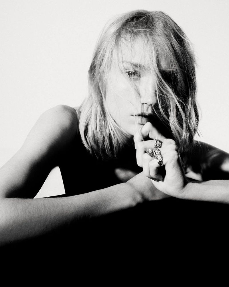 Close-up black and white portrait of a model with statement rings posing against a plain background for Pascale Monvoisin