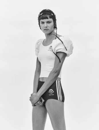 Black and white portrait of model Noor Khan wearing puffed-sleeve top and dark shorts for Simone Rocha in AnOther Magazine.