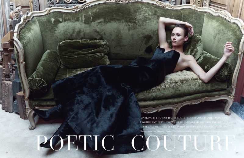 Model reclined on an antique green velvet sofa wearing a long black strapless gown for Vogue Arabia editorial