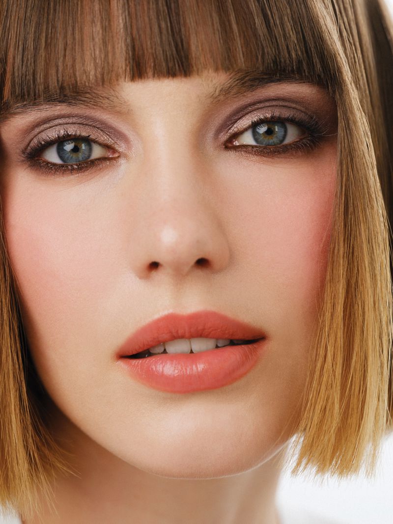 Close-up portrait of a woman with short brown bob hair, blue eyes, and peach lips for Mojeh Magazine
