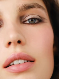 Close-up portrait of a woman showing detailed eye makeup and pink lips for Mojeh Magazine