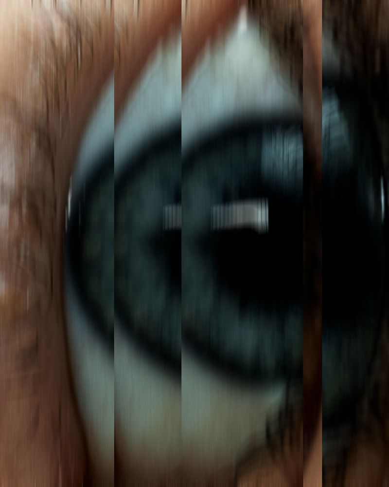 Macro shot of a human eye with blue iris and visible skin texture around the eye. Focus on the details of the eye.