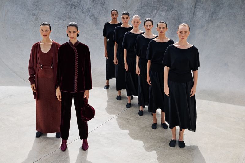Group of eight female models in dark clothing standing in a concrete skatepark for Vogue Portugal editorial We are the pattern