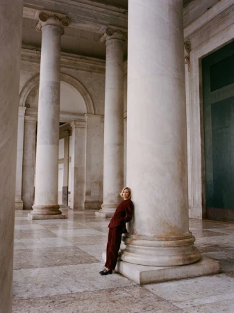 Model Anja Rubik leaning against a massive classical column in a grand stone portico for Financial Times HTSI Magazine.