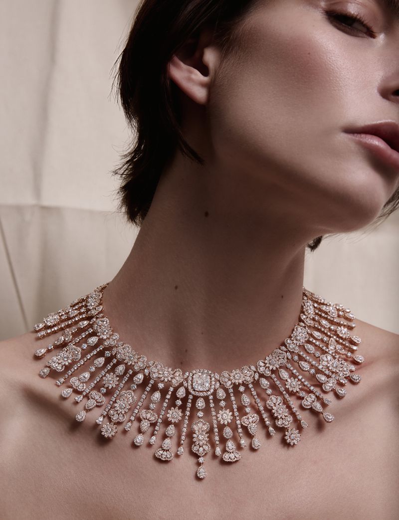 Close-up portrait of a model wearing an elaborate diamond-encrusted fringe necklace against a neutral backdrop