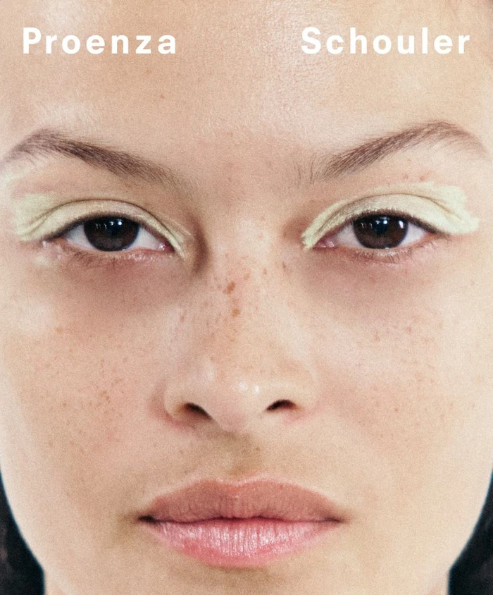 Close up beauty portrait of a woman with pale green eyeshadow and freckles for Proenza Schouler