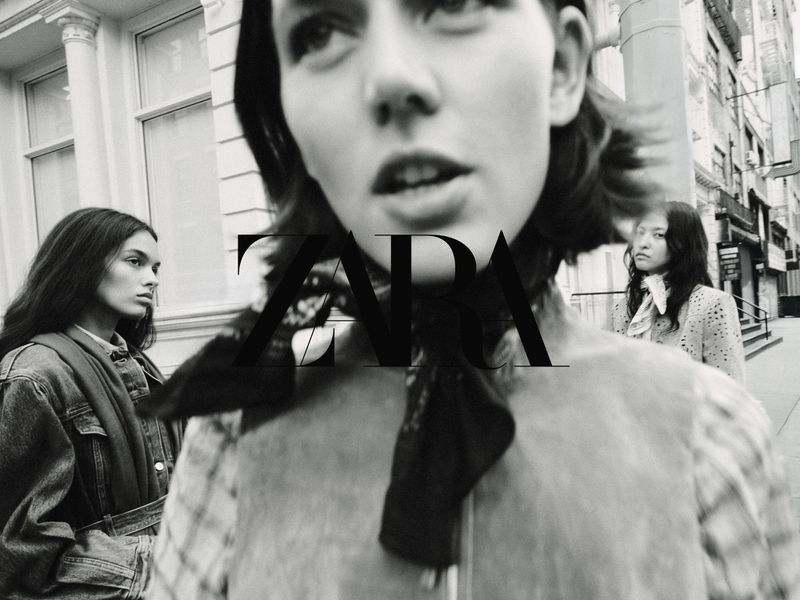 Close-up black and white portrait of a model with two other models in the background on an urban street, photographed by Bryan Liston for Zara.