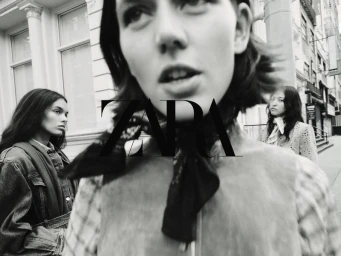 Close-up black and white portrait of a model with two other models in the background on an urban street, photographed by Bryan Liston for Zara.