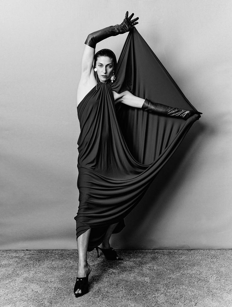 Model in draped dress and long black gloves posing dramatically against a neutral seamless backdrop for 10 Magazine Deutsch.