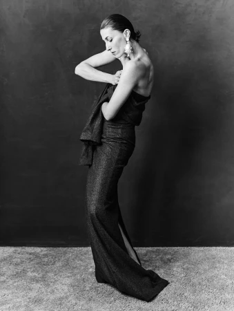 Model in strapless dark gown holding fabric against a textured dark backdrop for 10 Magazine Deutsch