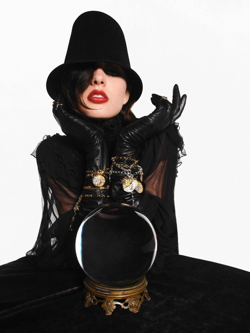 Model in black hat and gloves leaning over a crystal ball for V Magazine editorial Signs From Above