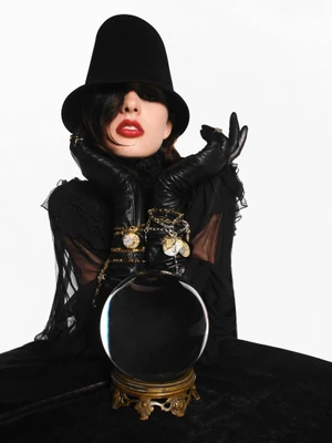 Model in black hat and gloves leaning over a crystal ball for V Magazine editorial Signs From Above