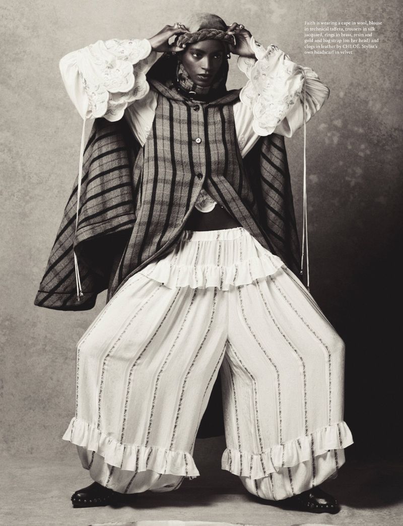 Model wearing a plaid sleeveless jacket and white ruffled trousers against a textured grey background.