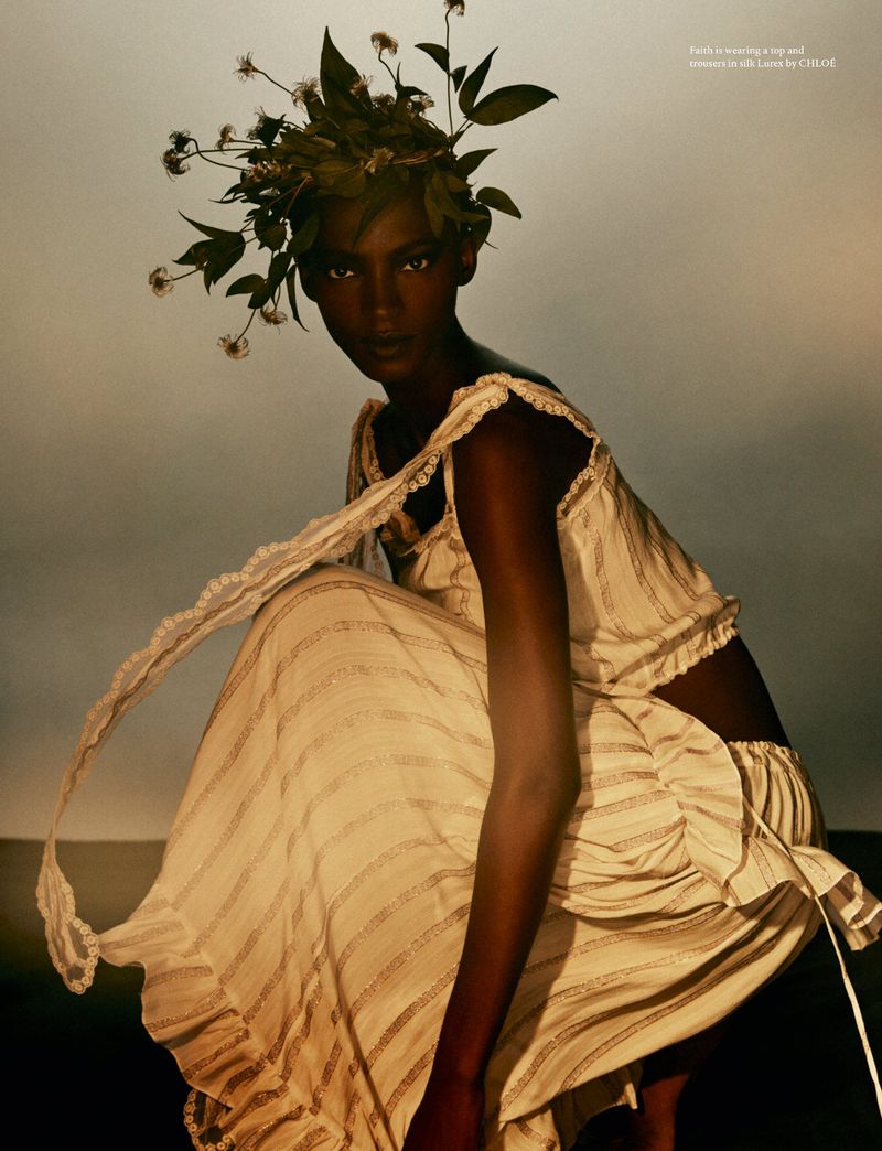 Model wearing white ruffled top and matching skirt with a botanical foliage crown in an editorial photograph for AnOther Magazine.