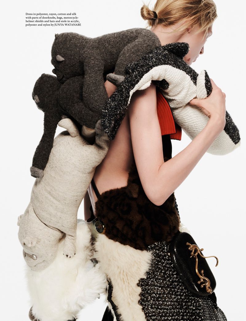 Model carrying stuffed animal garments on her back against a white seamless background for AnOther Magazine