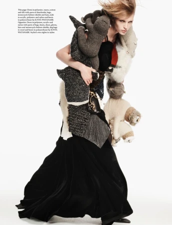 Model carrying stuffed animal garments wearing a black skirt against a white studio background