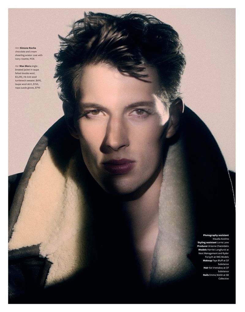 Close-up portrait of a male model wearing a dark heavy jacket with a cream shearling collar against a neutral studio backdrop