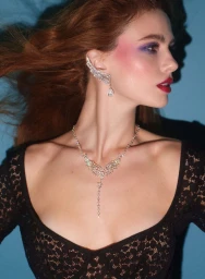Model Maria Klaumann wearing diamond earrings and necklace with purple eyeshadow against blue background