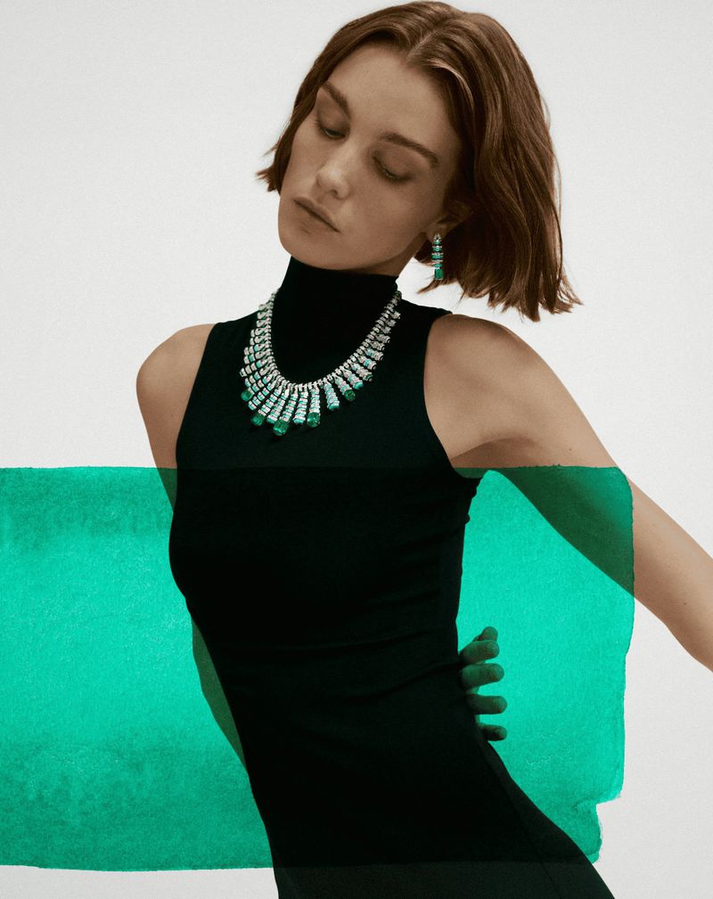 Model Luna Bijl wearing Cartier high jewelry necklace and earrings against a white background.