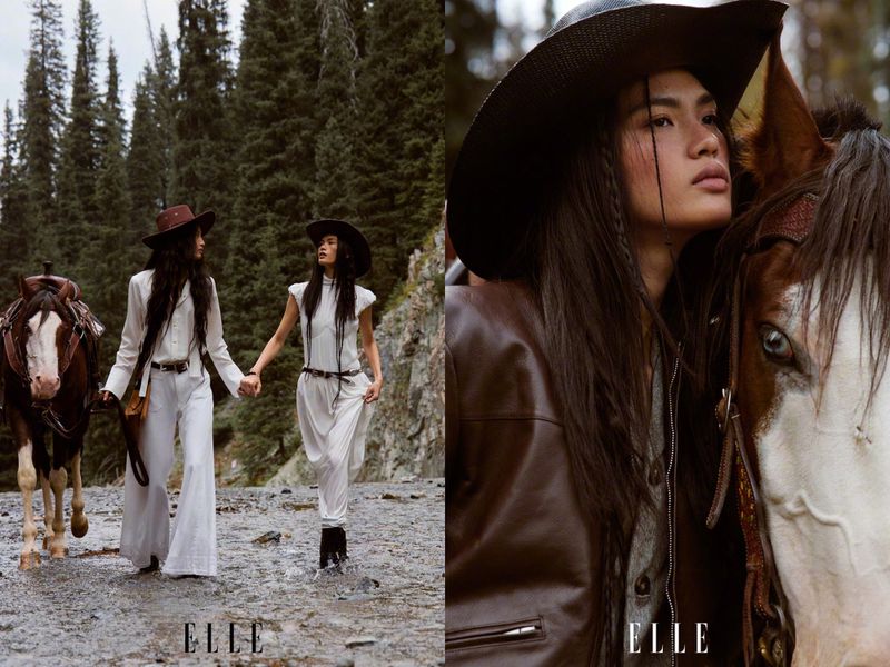 Two models wearing cowboy hats and western attire walking alongside horses through a wooded mountainous river landscape.