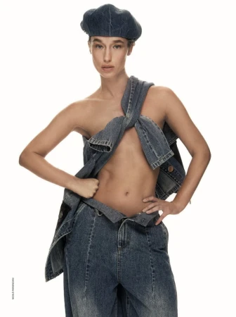 Model wearing a denim beret and styled denim pieces as a top with matching jeans against a white background