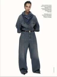 Model wearing a denim jacket and matching jeans with a blue bandana and dark belt against a white background.