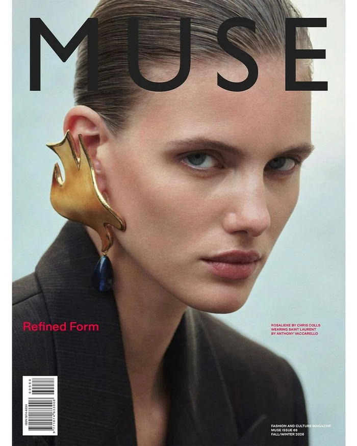 Close-up portrait of a model wearing a large sculptural gold ear cuff with a dark stone drop, part of Muse Magazine Fall/Winter 2026.