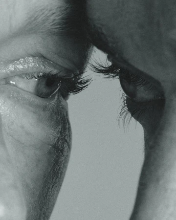 Close-up black and white macro shot of human eyes and eyelashes facing each other.